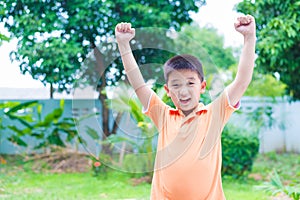 Successful Asian boy punching the air with his fists in air, smi