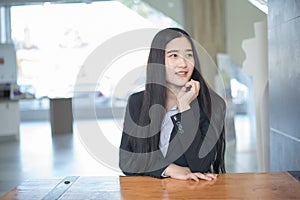 Successful asian business woman with folded hands smiling