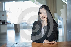 successful asian business woman with folded hands smiling