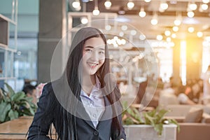 successful asian business woman with folded hands smiling