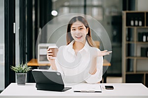Successful Asian Businesswoman Analyzing Finance on Tablet and Laptop at modern Office Desk tax, report, accounting, statistics,