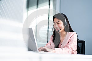 Successful Asian Businesswoman Triumphing Using Laptop. Business Woman Wearing Headphone