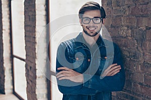 Successful bearded student in casual jeans outfit is standing n