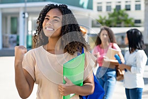 Successful black female student with group of latin american and caucasian young adults