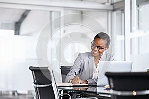 Successful black woman manager writing notes
