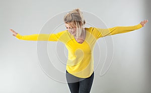 Successful blond woman smiling with arms opened for theatre gesture