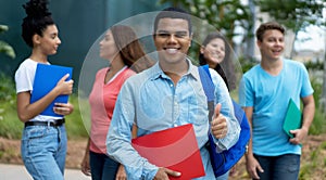 Successful brazilian male student with braces and group of multi ethnic young adults