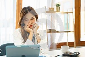 Successful business concept, Businesswoman resting chin on hand to reading financial data on tablet