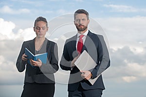 Successful business couple. Businessman and businesswomen. Successful business people standing over blue sky. Man hold