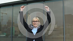 Successful business lady making winner gesture outdoors office building, freedom