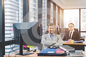 Successful business man with his staff in background at office