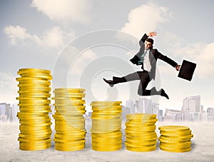 Successful business man jumping up on gold coin money