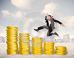 Successful business man jumping up on gold coin money