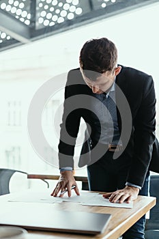 Successful business man signing documents in a modern office