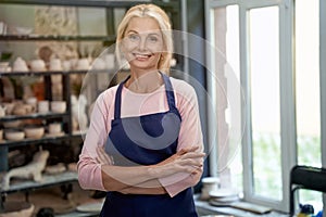 Successful business owner. Portrait of beautiful happy craft woman wearing apron looking at camera and smiling while