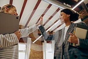 Successful business people giving each other a high five in a meeting. Corporate culture concept