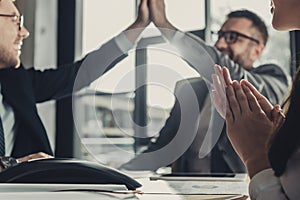 successful business people giving high five during meeting