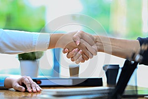 Successful business people shaking hands closing deal or making agreement after successful negotiations at meeting
