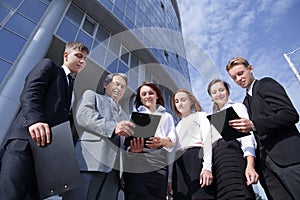 Successful business people team standing together outdoors near modern office building