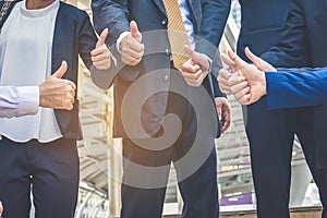 Successful business people with thumbs up and smiling, business