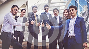 Successful business people with thumbs up and smiling, business