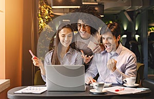 Successful business team looking at laptop happily