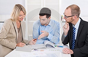 Successful business team sitting around a table in a meeting.