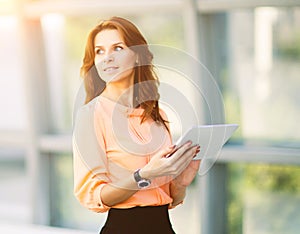 Successful business woman holding a digital tablet computer in the office