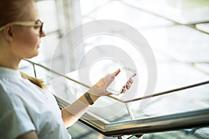 Successful business woman holding mobile phone with empty mock up copy space on the screen background for promotional content