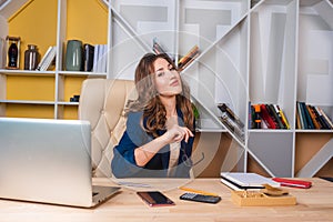 Successful business woman is sitting at the table, holding glasses in her hands