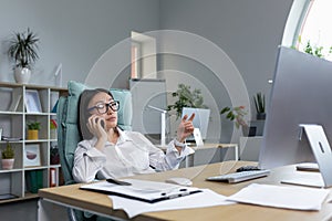 Successful business woman working in modern office, Asian woman talking on the phone, female worker wearing white shirt