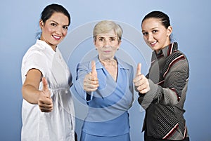 Successful business women giving thumbs up