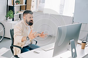 Successful businessman actively gesticulating at desk