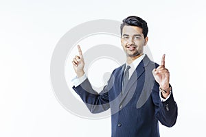 Successful businessman in black suit and tie pointing up with both hands