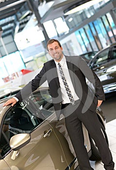 Successful businessman in a car dealership - sale of vehicles to