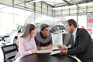 Successful businessman in a car dealership - sale of vehicles to photo