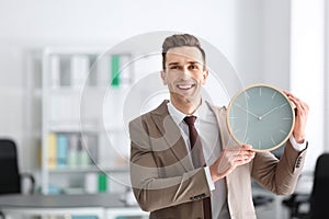Successful businessman with clock in office. Time management concept
