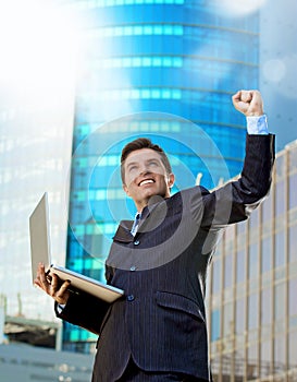 Successful businessman with computer laptop happy doing victory celebrating success