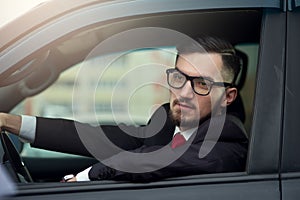 Successful businessman driving luxury car.