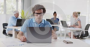 Successful businessman in earphones making video call on laptop