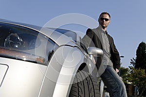 Successful businessman in front of his convertible