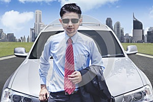 Successful businessman in front of luxury car