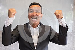 Successful businessman gesturing with happiness and gladness at