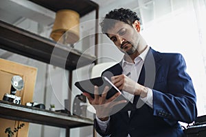 Successful businessman holding pointing typing digital tablet working at office. charming man Business man style