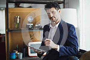 Successful businessman holding pointing typing digital tablet working at office. charming man Business man style looking at camera