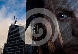 A successful businessman looks over construction of new industrial buildings. Double exposure of man face over commercial office