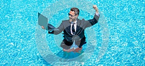 successful businessman man remote working online wth laptop in summer swimming pool on business vacation