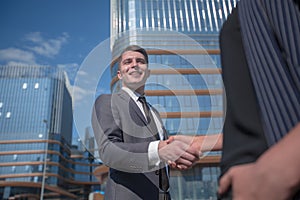 Successful businessman meeting a young employee with a handshake.