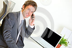 Successful businessman in office making phone call