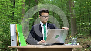 Successful businessman relaxing outdoors after hardworking, eco-friendly office